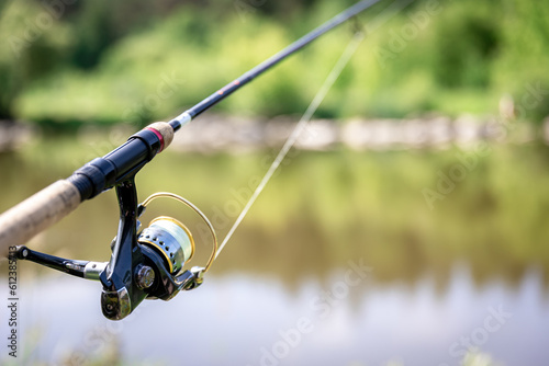 Fishing reel close-up on the background of the river.