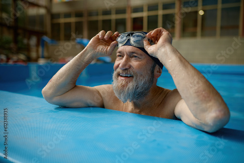Healthy senior man swimming in indoor pool enjoying sportive lifestyle