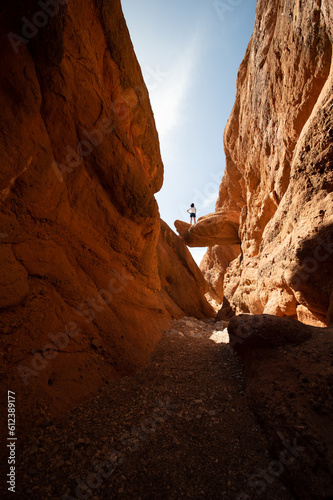 Stunning view of a tourist standing on a rock. Gorges du Dades  Ourzazate. The Dad  s Gorges  are a series of rugged wadi gorges carved out by the Dad  s River in Morocco.
