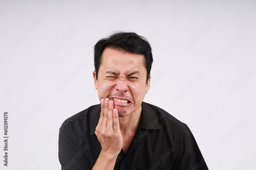Asian man wearing black shirt put your hands on your mouth painful expression Asian man wearing black shirt put your hands on your mouth painful expression
