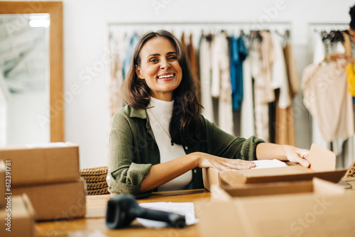 Boutique owner preparing orders for drop shipping in her clothing store