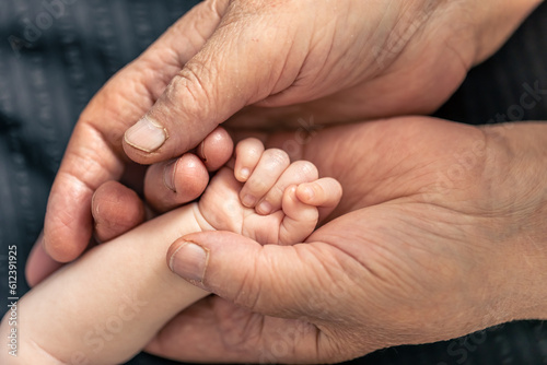 Hands of senior person and little baby close up. © puhimec