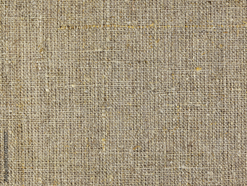 Rough homespun cloth top view. A background of a scratchy burlack material in an even light brown color. Fabric made from hemp Background texture of woven canvas. Coarse-grained linen close up.