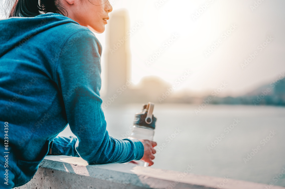 Asian women standing to see the city view after jogging a morning workout in the city.