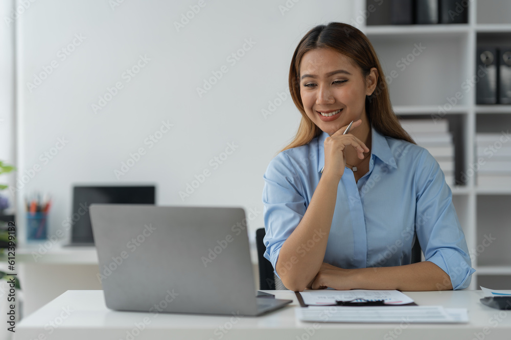 Businesswoman using a laptop computer with documents Calculator, notebook, on the table, planning, analyzing financial reports. business plan investment financial analysis concept Businesswoman using a laptop computer with documents Calculator, notebook, on the table, planning, analyzing financial reports. business plan investment financial analysis concept
