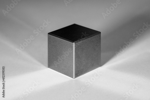 A tungsten cube with reflections and shadows against a white background photo