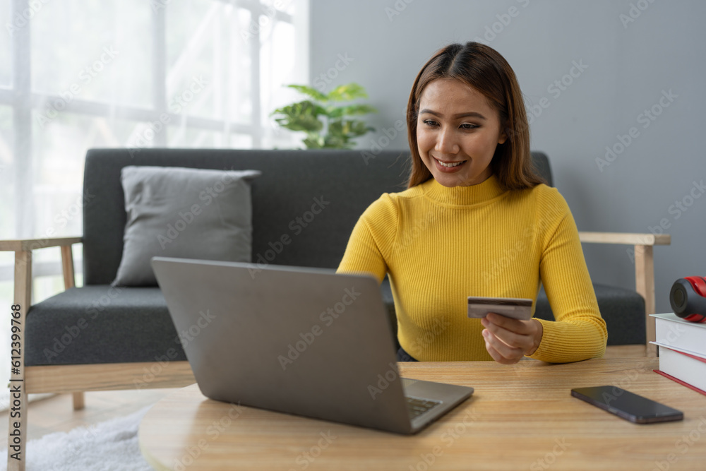 Business woman, young woman holding credit card and using laptop computer for online shopping, e-commerce, banking, internet application, spending money, working from home startup business ideas Business woman, young woman holding credit card and using laptop computer for online shopping, e-commerce, banking, internet application, spending money, working from home startup business ideas