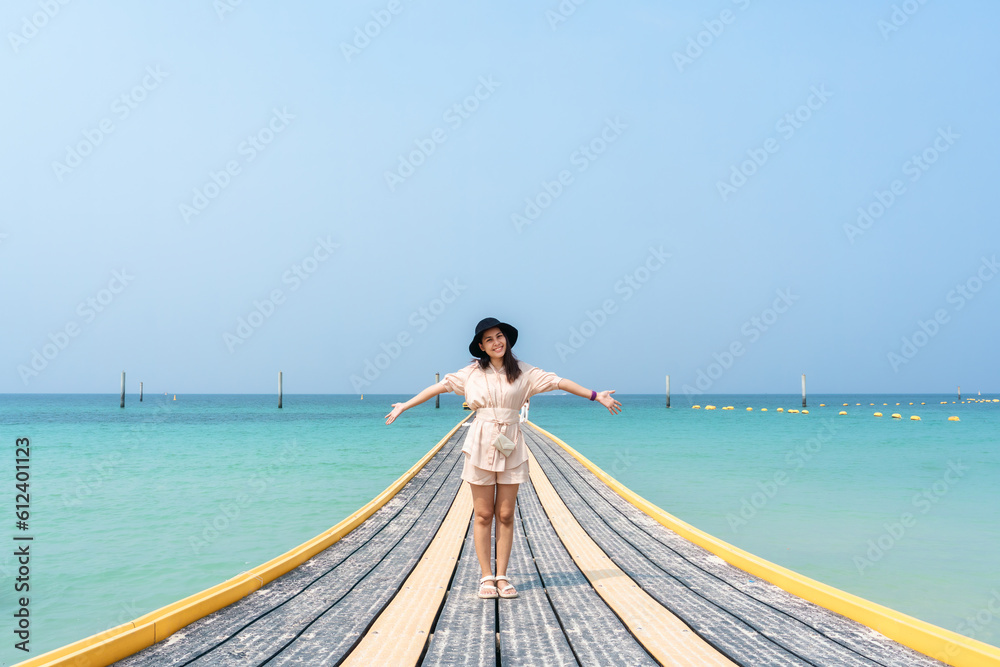 Young asian woman standing on pontoon walkway in tropical sea