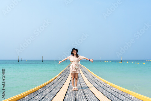 Young asian woman standing on pontoon walkway in tropical sea © Mumemories