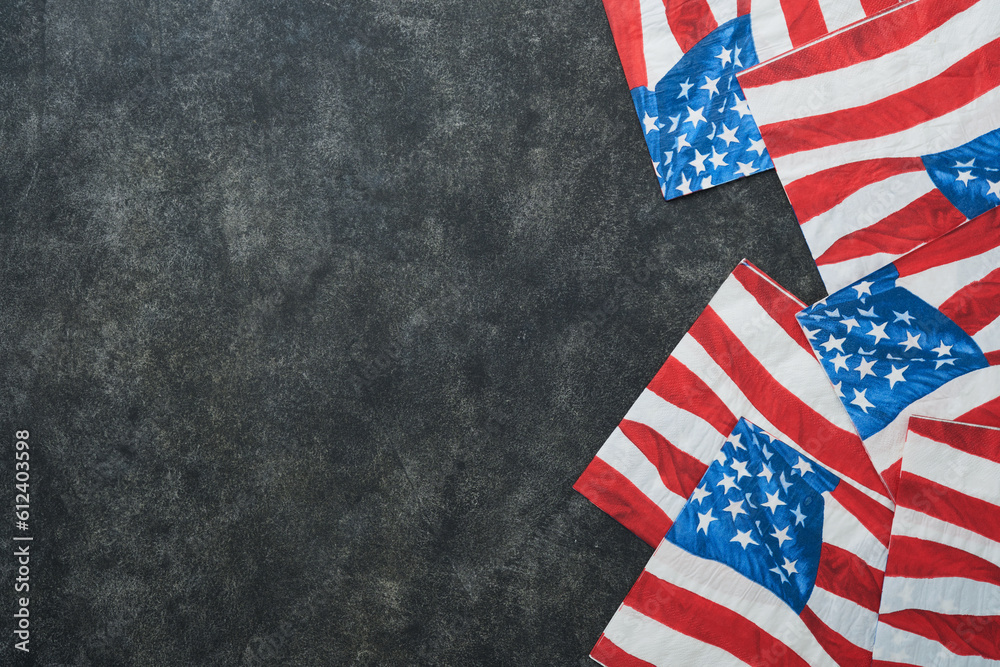 Fototapeta premium 4th of July background. USA paper fans, Red, blue, white stars, balloons, gold confetti on gray dark concrete background. Happy Labor, Independence or Presidents Day. American flag colors. Top view.
