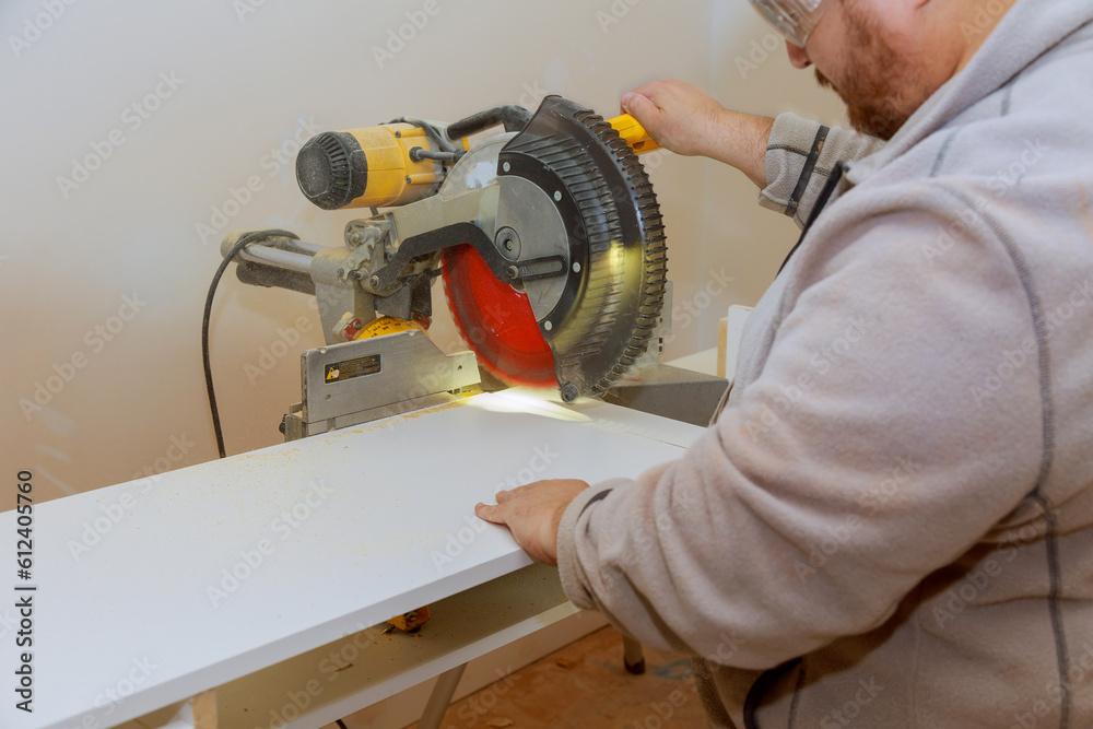Circular saw is used by worker to cut melamine board for shelves heavy building Circular saw is used by worker to cut melamine board for shelves heavy building