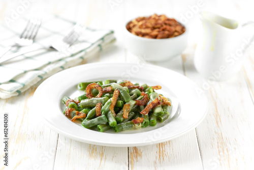 Traditional green bean casserole on a white wooden table.