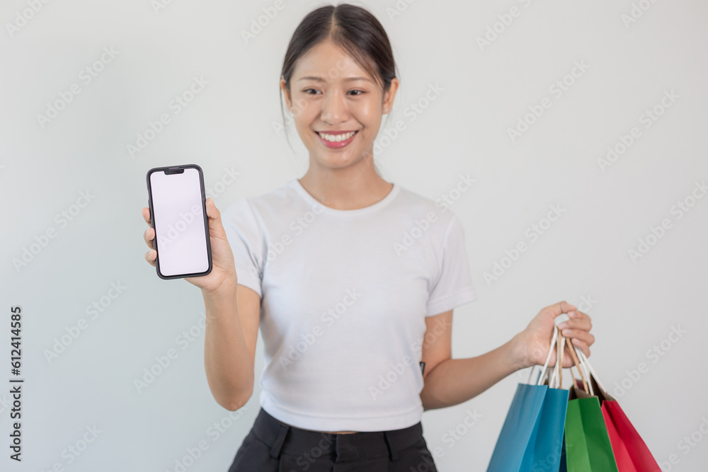 Portrait of a beautiful smiling Asian woman holding a smart phone. online shopping concept Portrait of a beautiful smiling Asian woman holding a smart phone. online shopping concept