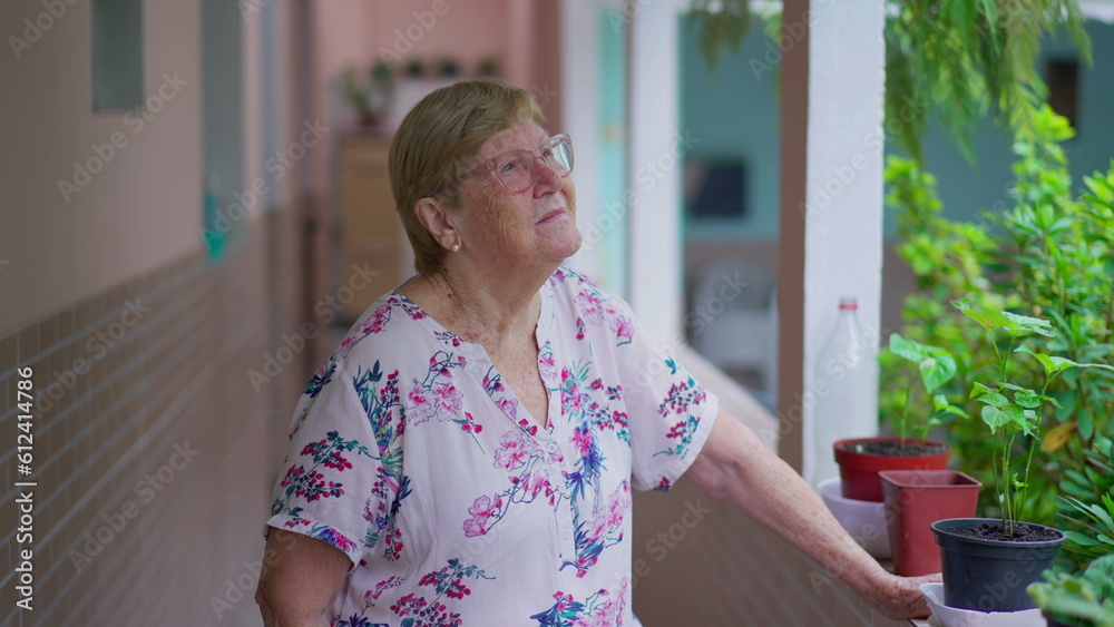 Pensive elderly woman gazing in outside home backyard. Retired Thoughtful senior female person in her 80s daydreaming in residence Pensive elderly woman gazing in outside home backyard. Retired Thoughtful senior female person in her 80s daydreaming in residence