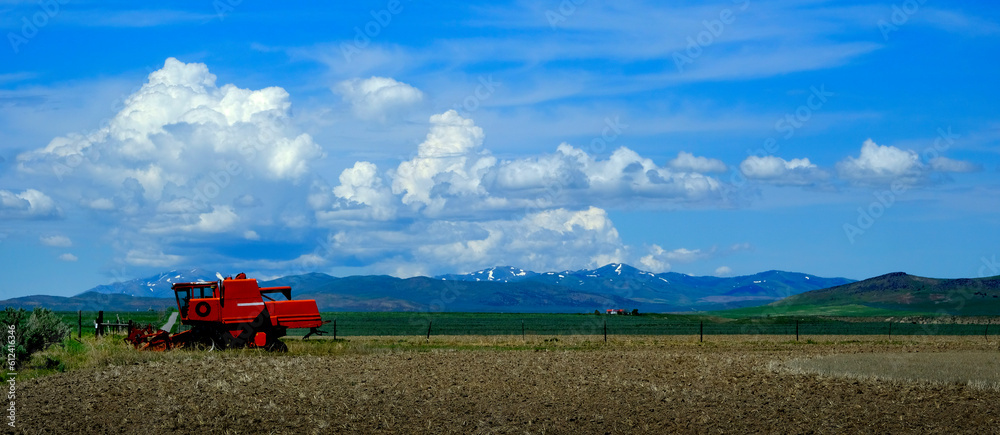 Fototapeta premium Old Red Farm Equipment in Country Farm Field