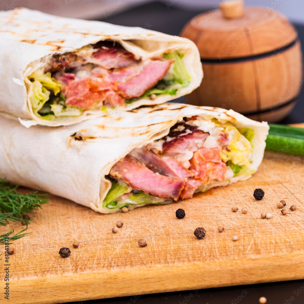 Delicious kebab with meat, lettuce, tomato, onion and sauce with french fries. Delicious kebab with meat, lettuce, tomato, onion and sauce with french fries.
