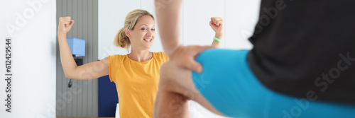 Happy woman showing masculine strength with hands in bed with man