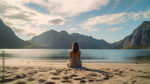 Beautiful girl relaxing on a beach holiday with epic mountains in the distance