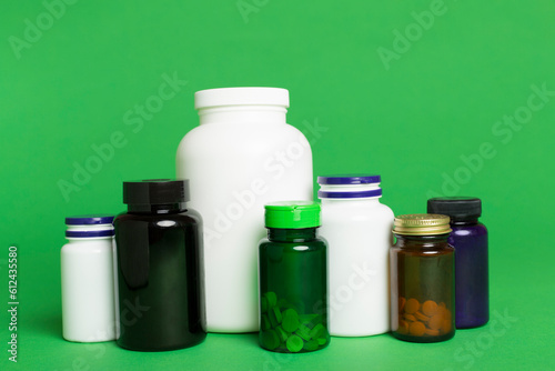 Plastic bottles for vitamins on color background