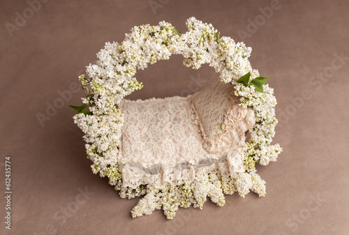 Basket with a background for a baby photo shoot.Basket for a newborn.Flower basket for a photo shoot. Basket on a beige background.White lilac.