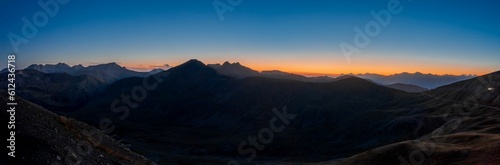 Panoramic shot of the rocky mountains during scenic orange sunset in the blue sky