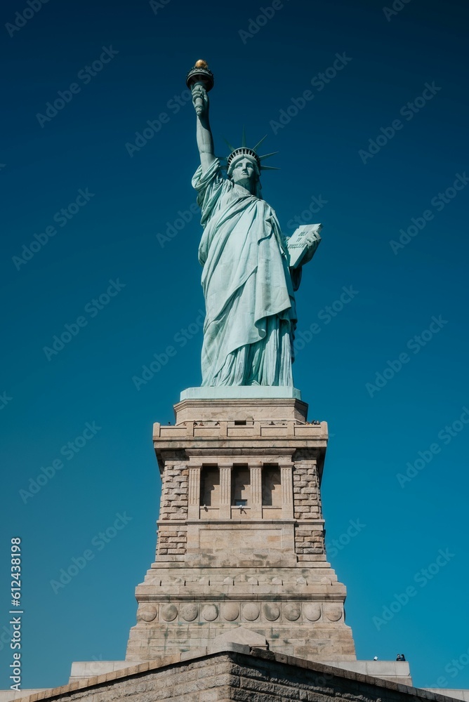 Vertical shot of the historic Statue of Liberty under a clear blue sky