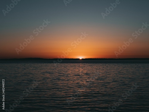 Beautiful shot of a calm lake during a sunset © Kenneth Bruce/Wirestock Creators