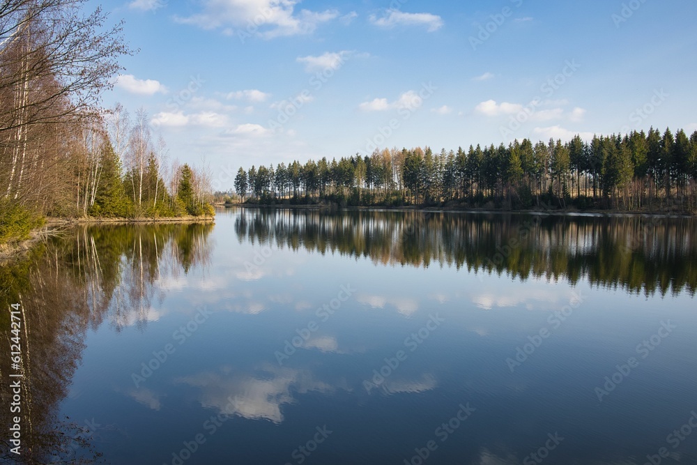Autumn trees and a blue sky with clouds reflecting in the water. Autumn trees and a blue sky with clouds reflecting in the water.