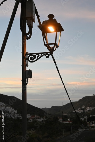 Street lamp glowing in the background of the evening sky photo