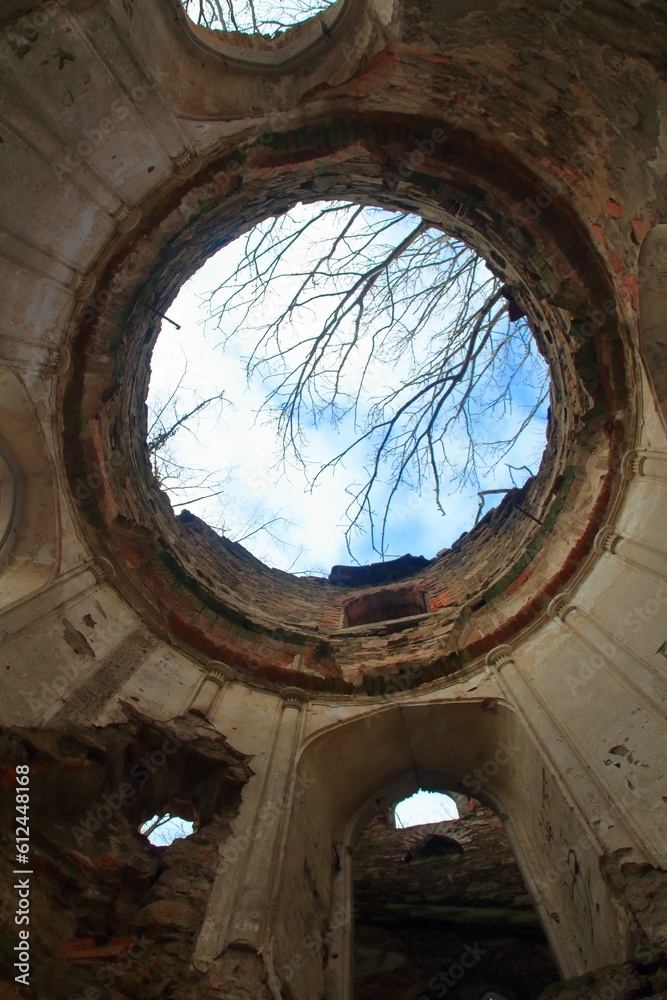 Low angle vertical shot of a ruined building with blue sky in the background