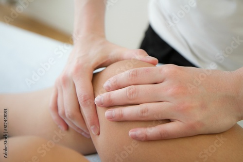 Caucasian hands doing massage of a knee for pain relief, physical therapy