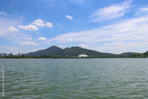 Scenic shot of an ocean with a mountain range in the background and high skyscrapers on the coast