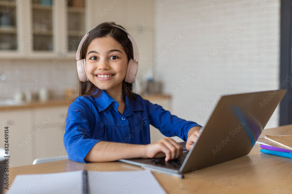Joyful Schoolgirl Typing On Laptop Computer Posing Sitting At Home