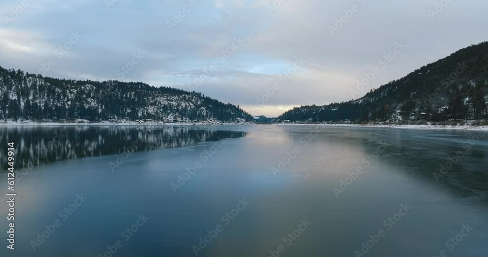 Drone view over forested hills on a waterfront during wintertime Drone view over forested hills on a waterfront during wintertime
