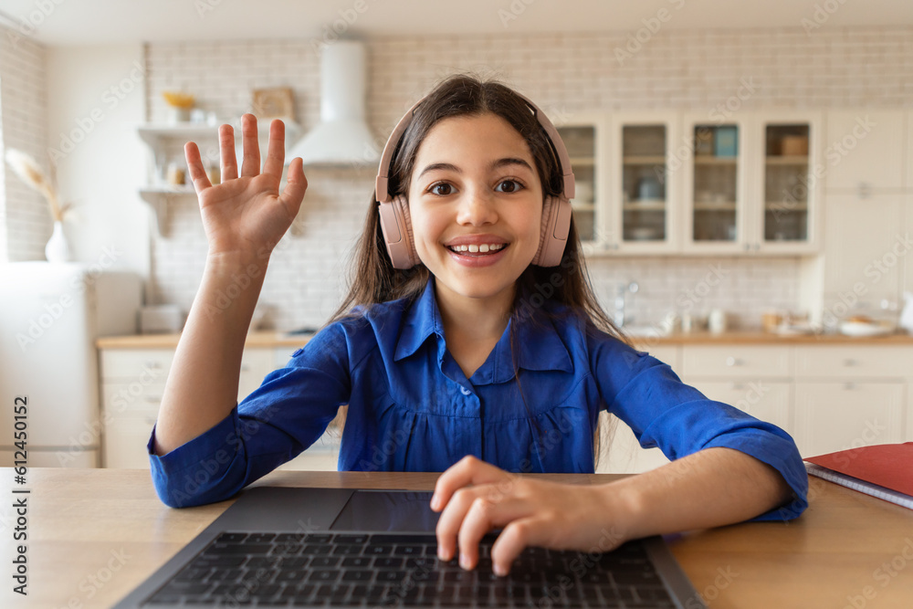 Schoolgirl Gesturing Hello To Computer Web Camera Learning Online Indoor Schoolgirl Gesturing Hello To Computer Web Camera Learning Online Indoor