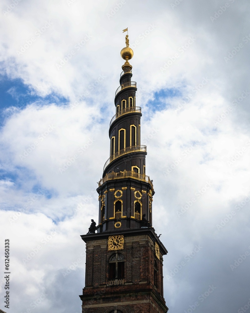 Vertical shot of the tower of Church of Savoir over a background of a cloudy sky