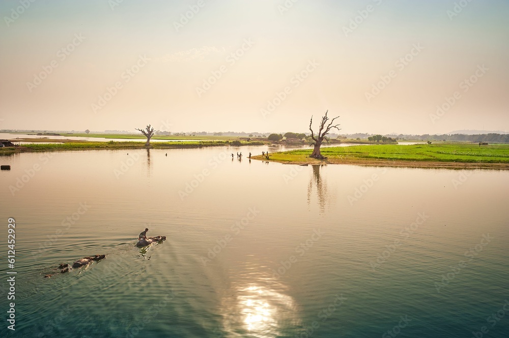 Breathtaking view of the sun and the colorful sky reflected on a body of water Breathtaking view of the sun and the colorful sky reflected on a body of water