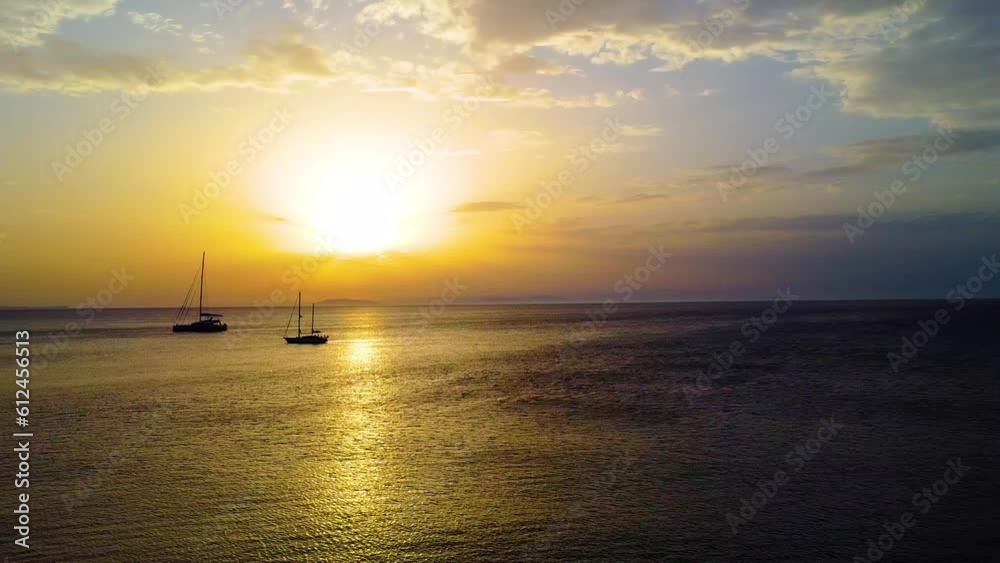 Drone shot over a seascape at sunset with boats swimming around Drone shot over a seascape at sunset with boats swimming around