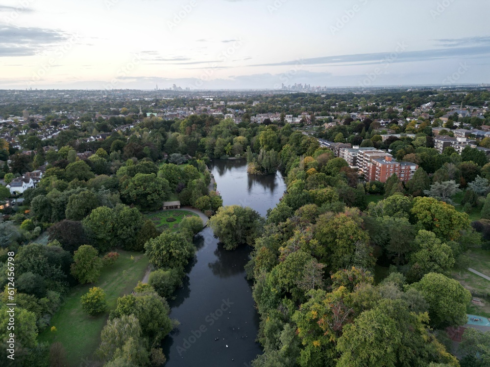 High-angle shot of a city full of buildings, green trees, fields and river at Bromley borough.