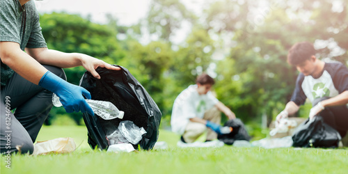 Teamwork represents power. collecting garbage in public places Hands collecting plastic bottles with a group of young people volunteering to collect plastic bottles in garbage bags on the forest floor