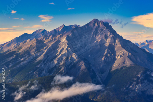 Last rays of the sun illuminate the sheer granite ridges of the magnificient Cascade mountain in this view from Sulphur mountain in the Canada rockies