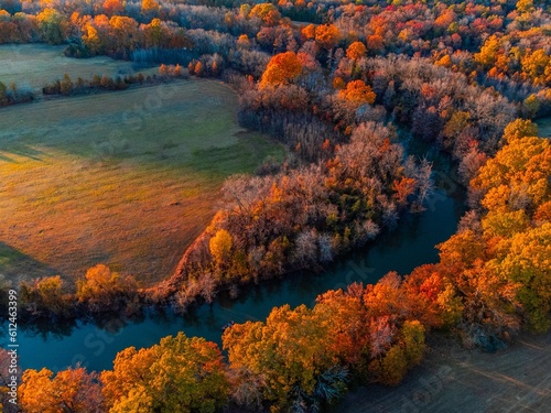 Aerial view of beautiful colorful autumn trees on the shore of a river