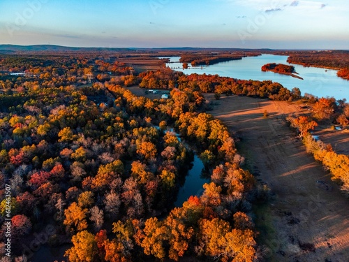 Aerial view of beautiful colorful autumn trees on the shore of a river