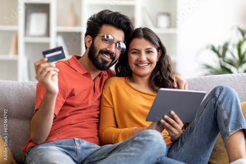 Online Payments. Smiling Indian Spouses With Digital Tablet And Credit Card