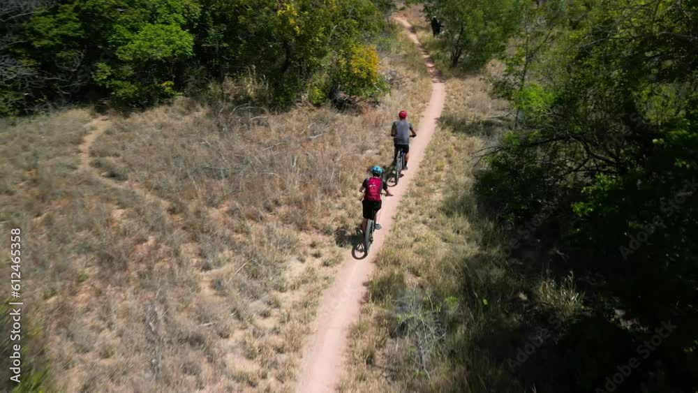 People riding a bicycle through Pallarenda mountain trail in Townsville, Queensland, Australia People riding a bicycle through Pallarenda mountain trail in Townsville, Queensland, Australia