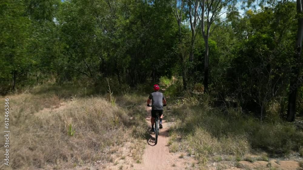 Person riding a bicycle through Pallarenda mountain trail in Townsville, Queensland, Australia Person riding a bicycle through Pallarenda mountain trail in Townsville, Queensland, Australia