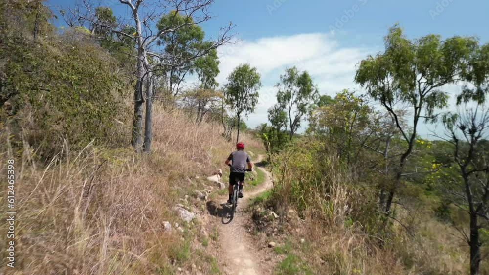 Person riding a bicycle through Pallarenda mountain trail in Townsville, Queensland, Australia Person riding a bicycle through Pallarenda mountain trail in Townsville, Queensland, Australia