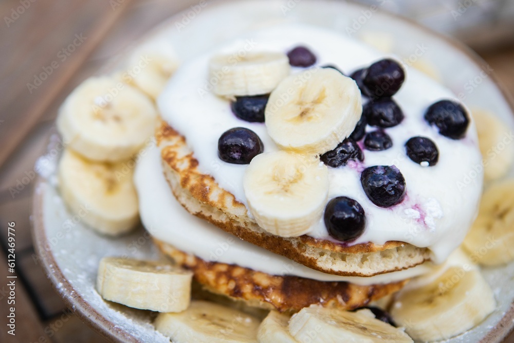 Closeup of banana slices and shiny Blueberry on white plate