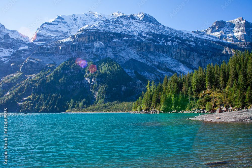 A stunning landscape featuring Lake Oeschinensee nestled in the Swiss Alps, showcasing its natural beauty and serenity.