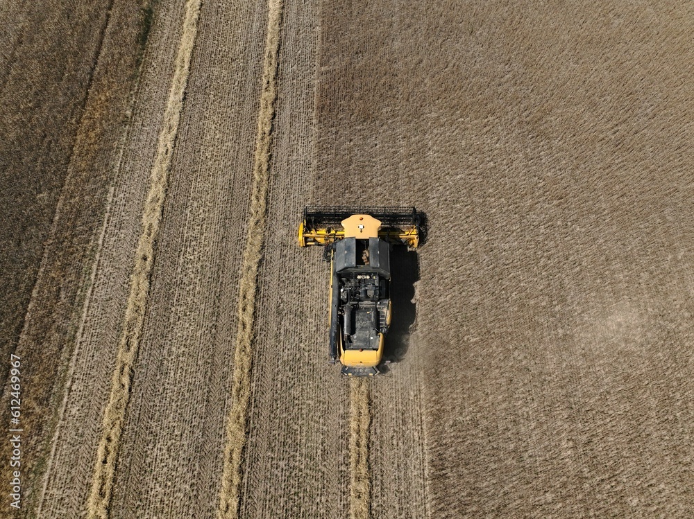 High-angle shot of a truck harvesting cereal from fields during the day High-angle shot of a truck harvesting cereal from fields during the day